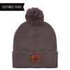 SP15 Sportman Heather Brown winter knit cap beanie with pom pom with a circle engraved logo on authentic leather patch in bulk