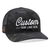 The Richardson 862 Multicam Camo Trucker Hat is a black camo-patterned cap with mesh back and white embroidered text saying Custom and YOUR LOGO HERE. It features an American flag patch on the brim, perfect for showcasing corporate logos on custom hats.