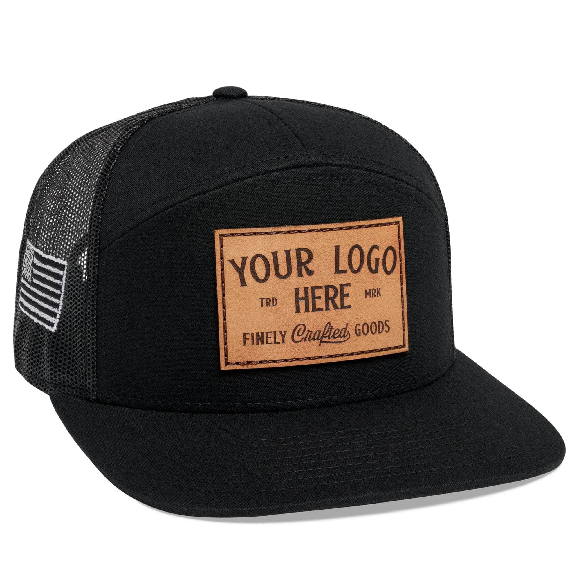 The C58-CTM by BLVNK is a black 7-panel flat bill trucker hat with a mesh back and leather patch, ideal for displaying corporate logos. It features Custom Your Logo Here in white embroidery on the front, with a curved brim and structured crown for a sleek appearance.