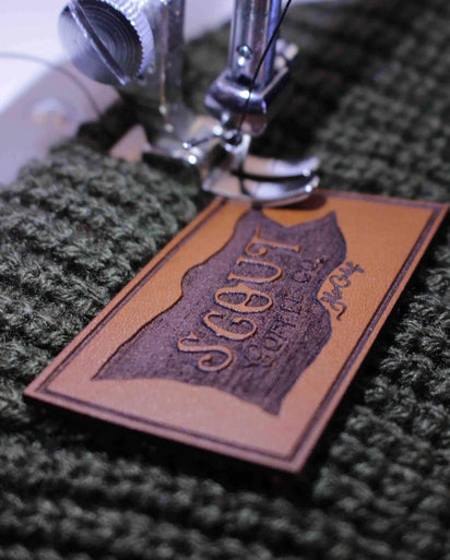 Leather patch being carefully machine-sewn onto a custom hat by Dekni Creations, made in the USA for lasting durability