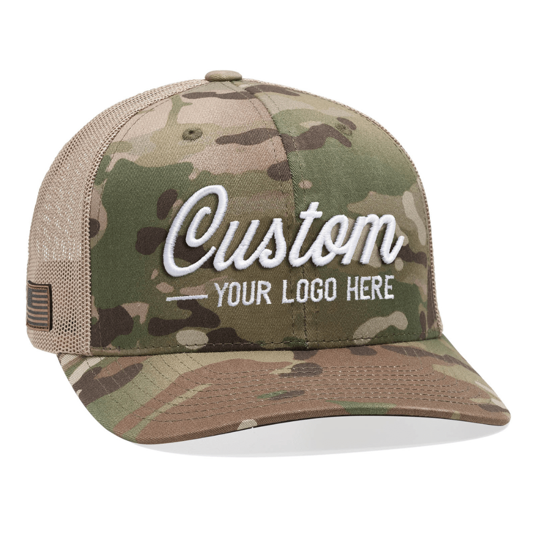 The Yupoong 6606MC – Multicam 6-Panel Trucker Hat is perfect for promoting branded hats, featuring a camo pattern with a mesh back and white embroidered text on the front for your custom logo. The curved brim and small flag patch complete this impressive accessory.