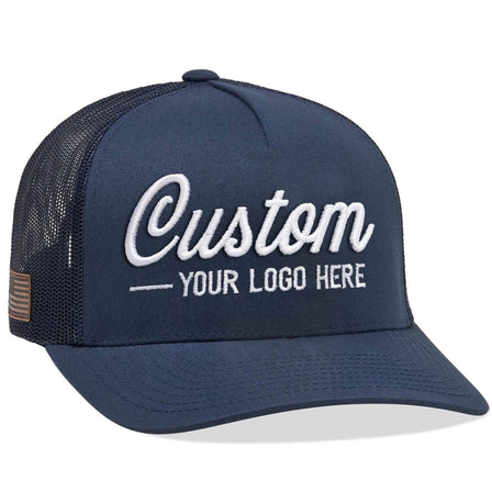 A Yupoong 6506(T) – 5-Panel Trucker Hat in navy blue with Custom Your Logo Here embroidered in white on the front, featuring a mesh back and side patch, perfect for showcasing your company logo.