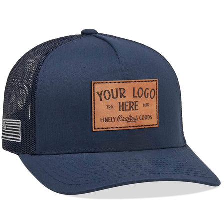 A Yupoong 6506(T) – 5-Panel Trucker Hat in navy blue with Custom Your Logo Here embroidered in white on the front, featuring a mesh back and side patch, perfect for showcasing your company logo.