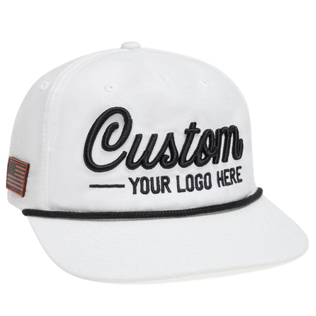 The BLVNK Private Label C55-N hat is a white baseball cap with black Custom - Your Logo Here embroidery, featuring a small American flag patch on the side and black rope detail across the brim, ideal for showcasing your company logo in bulk.